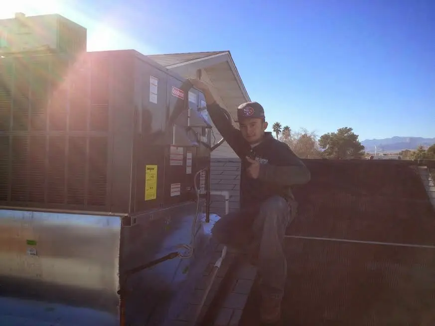 HVAC technician performing Boiler Repair on a rooftop unit in Fulshear